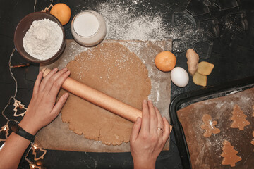 cut gingerbread out of the dough using a gingerbread mold, top view, raw dough with cinnamon...