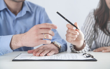 Couple with divorce contract and ring. Divorce