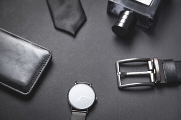Tie, belt, wallet, wristwatch, perfume on the black background.