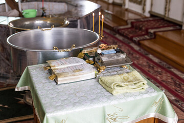 Accessories for the christening of children icons of candles and font, cross, scissors, Bible , the Ortodox Church. The Sacrament of Children