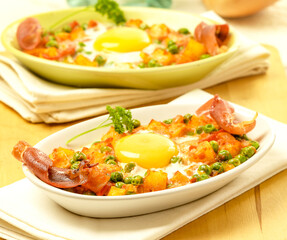 huevos al horno con jamón, guisantes, patatas y tomate