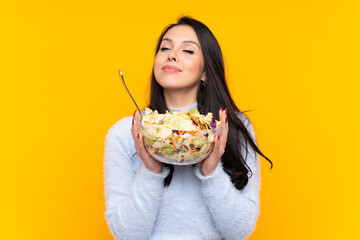 Young Colombian girl holding a salad over isolated background