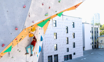 A man is climbing a climbing wall
