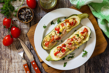 Healthy food. Baked zucchini stuffed with meat and tomatoes on rustic wooden table. Top view flat lay.