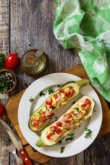 Healthy food. Baked zucchini stuffed with meat and tomatoes on rustic wooden table. Top view flat lay. Free space for your text.