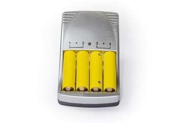 Rechargeable AA batteries inserted in battery charger on white background