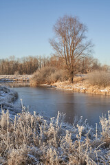 Breath of winter, first ice on the lake, dawn on a frosty morning with frost on the grass, close-up of frost, patterns on the first ice.