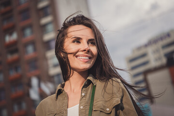 Photo of charming pretty young lady wear brown shirt smiling walking looking side outside sunny street