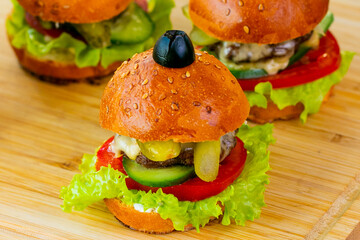 Delicious mini beef burgers isolated on a wooden(bamboo) tray.