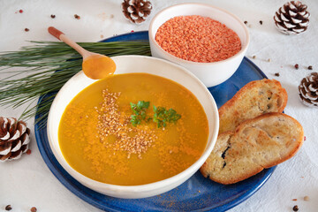Orange soup in a bowl, pumpkin, carrot or coral lentils
