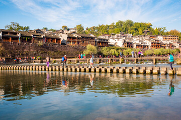 the river, the boat, stone bridge and the old houses at ancient phoenix town in the morning at...