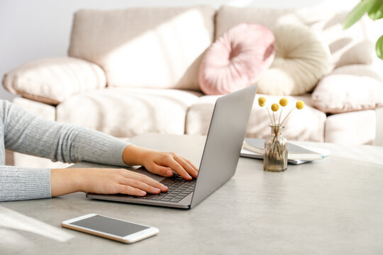 Work From Home Concept. Cropped Shot Of Woman's Hands Typing On Laptop. Female Freelancer Working At Her Living Room. Close Up, Copy Space For Text.