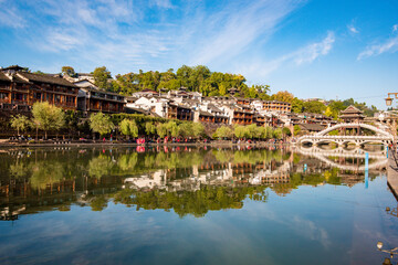 the river, the boat, stone bridge and the old houses at ancient phoenix town in the morning at Hunan, China.
