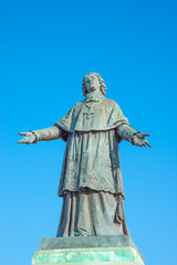 Fototapeta premium Statue of a Bishop Henri de Belsunce at magnificent Cathedral de la Major in Marseille illuminated with sunset at blue sky, Marseille, France, details, closeup.