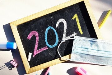 2021 Hand writing chalk on blackboard with face mask, Happy new year concept, back to school