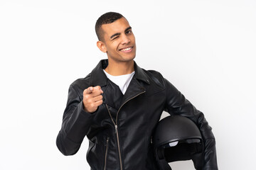 Young handsome man with a motorcycle helmet over isolated white background points finger at you