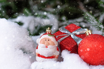 Fototapeta na wymiar Christmas red decor ball on a snow-covered spruce branch. Happy New year, greeting card with natural snow. Copy space.