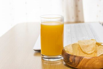 休憩時間におやつを食べ、ノートパソコンを使うイメージ