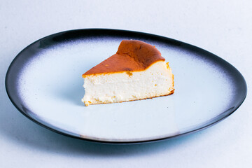 Fototapeta premium San sebastian cake in a ceramic plate isolated on a white background close up.