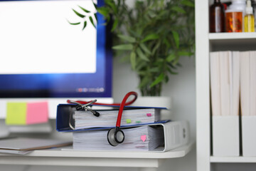 In medical office there is stethoscope on documents.