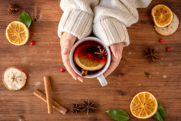 German tradition winter Christmas market new year holidays festival drink tea punch Gluhwein Mulled hot warm red Wine in apple orange mug spices citrus aromatic cinnamon star anise woman hand hold