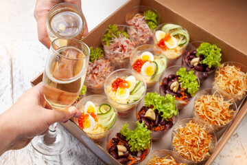 Champagne, tartlets, seafood salads. Cardboard box with food with home delivery. Gift for holiday, party, family dinner. Catering. Delicious snacks.
