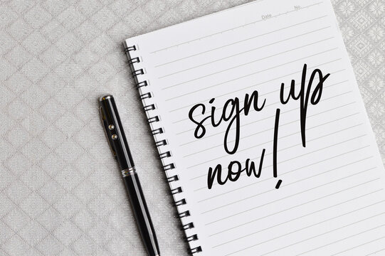 Top view of pen and notebook written with text SIGN UP NOW!. Business and education concept.
