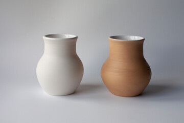 Fototapeta na wymiar Two ceramic milk pots of white and terracotta clay. Rustic style.