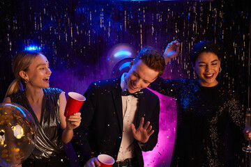 Portrait of three happy teenagers dancing and laughing while enjoying prom night