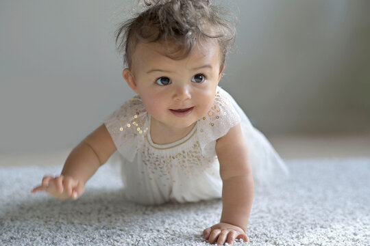 Cute 8-month-old baby girl crowling on all four