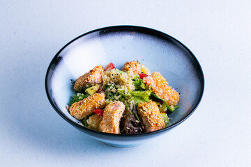 Salmon salad in a blue ceramic bowl isolated on a white background close up.