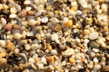 multicolored small stones on the shore on a yellow background