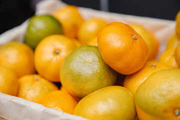  Fresh mandarins on fruit market, close up. Boxes full of ripe mandarin oranges for sale on farmers market. Fresh fruit display in shop. Juicy mandarin orange at the greengrocer's stall.