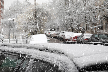 Parked cars covered with snow. Snow storm, thaw, frost and natural disasters