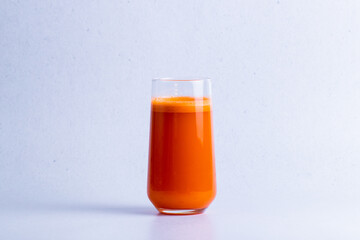 Fresh healthy carrot juice in a glass isolated on a white background.