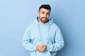 Caucasian man over isolated blue background laughing