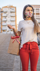 Obraz premium Latin woman doing Christmas shopping with protective mask