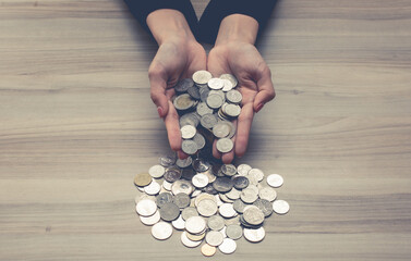 A woman hands holding money coins on table , donation, charity, giving, Business financial success saving concept,