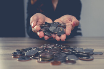A woman hands holding money coins on table , donation, charity, giving, Business financial success...