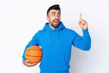 Caucasian man over isolated white background playing basketball and having an idea