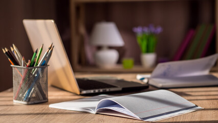 Creative person's workplace, laptop and notebooks on the table by the window