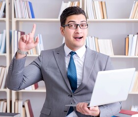 Businessman with a laptop working in the library