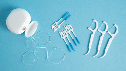 Home dental care kit. Different tools for dental care on blue background. Floss picks floss...