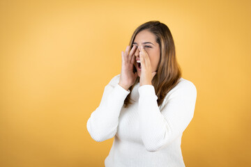Young caucasian woman over isolated yellow background shouting and screaming loud to side with hands on mouth