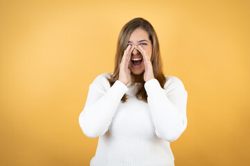Young caucasian woman over isolated yellow background shouting and screaming loud to side with hands on mouth