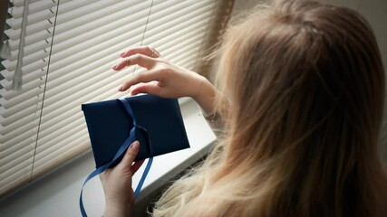 Surprise gift. Young woman unpacks romantic love surprise associated with fond memories of happiness 