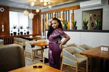 Beautiful african american woman in red leather costume pose at restaurant.
