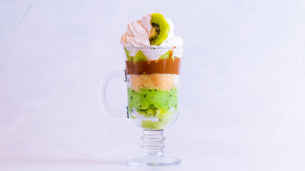 Delicious kiwi dessert in a glass cup isolated on a white background close up.