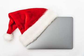 Obraz na płótnie Canvas Laptop with Santa Claus hat for Christmas