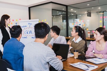 Young smart asian business female leader in a casual meeting with her teamwork colleagues at the modern design office presenting sales strategy plan and data or forecast for a project goal schedule
